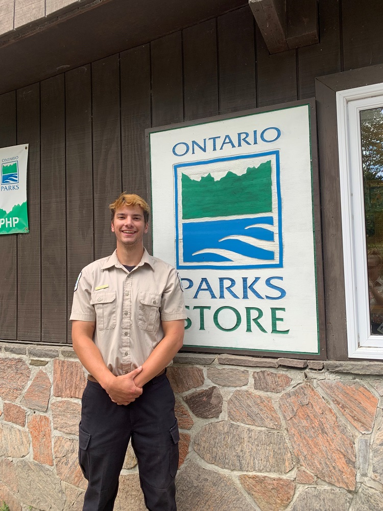 staff standing beside park store sign