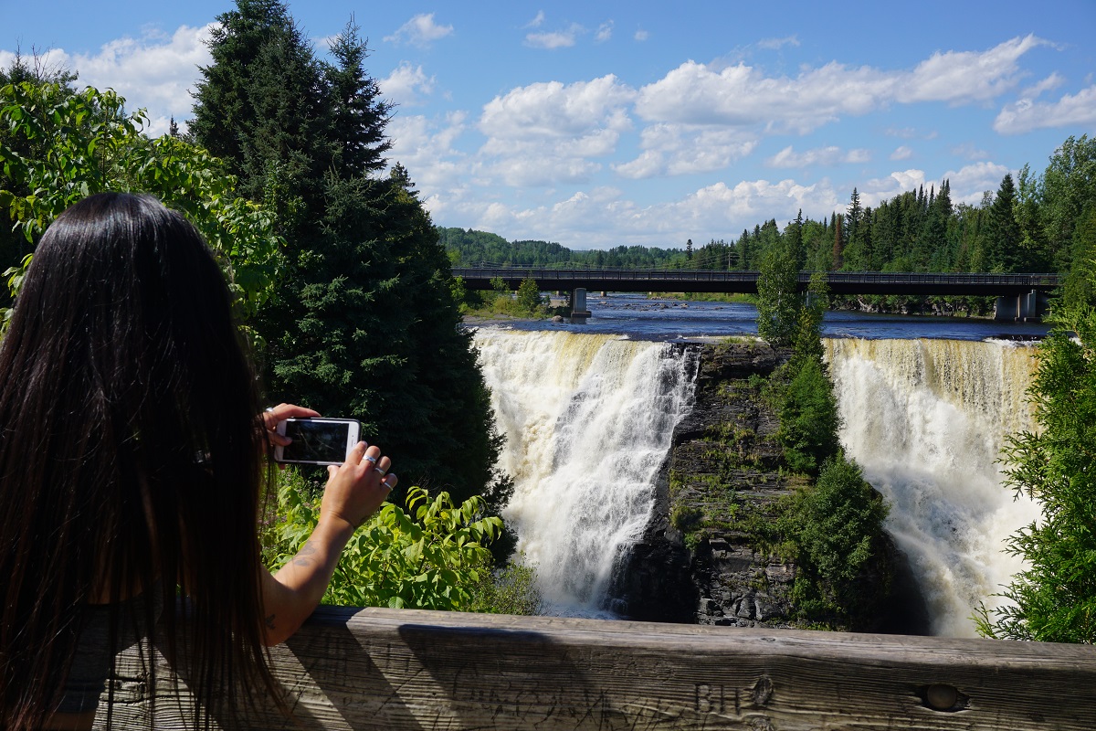 Visitor taking a photo of the waterfall