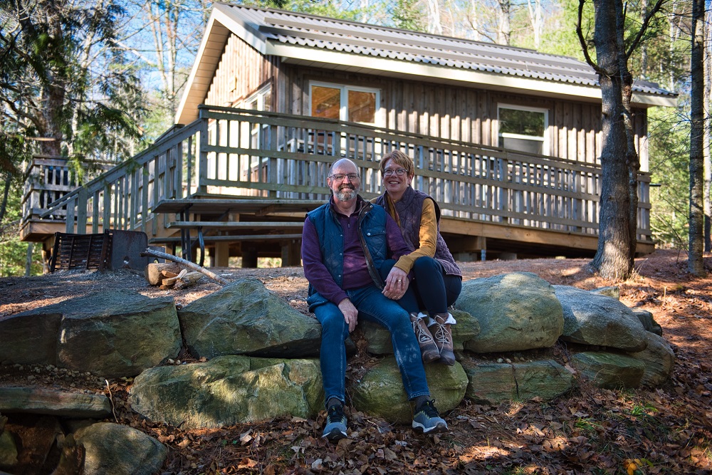 couple sitting in front of cabin