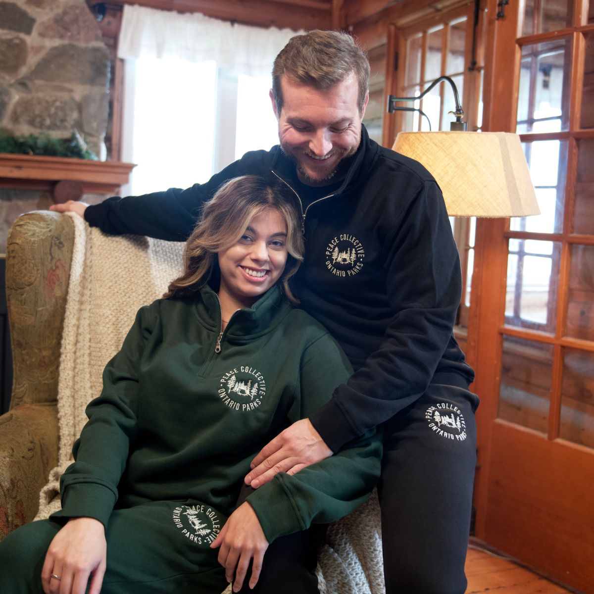 couple wearing green and black quarter-zip sweaters and joggers