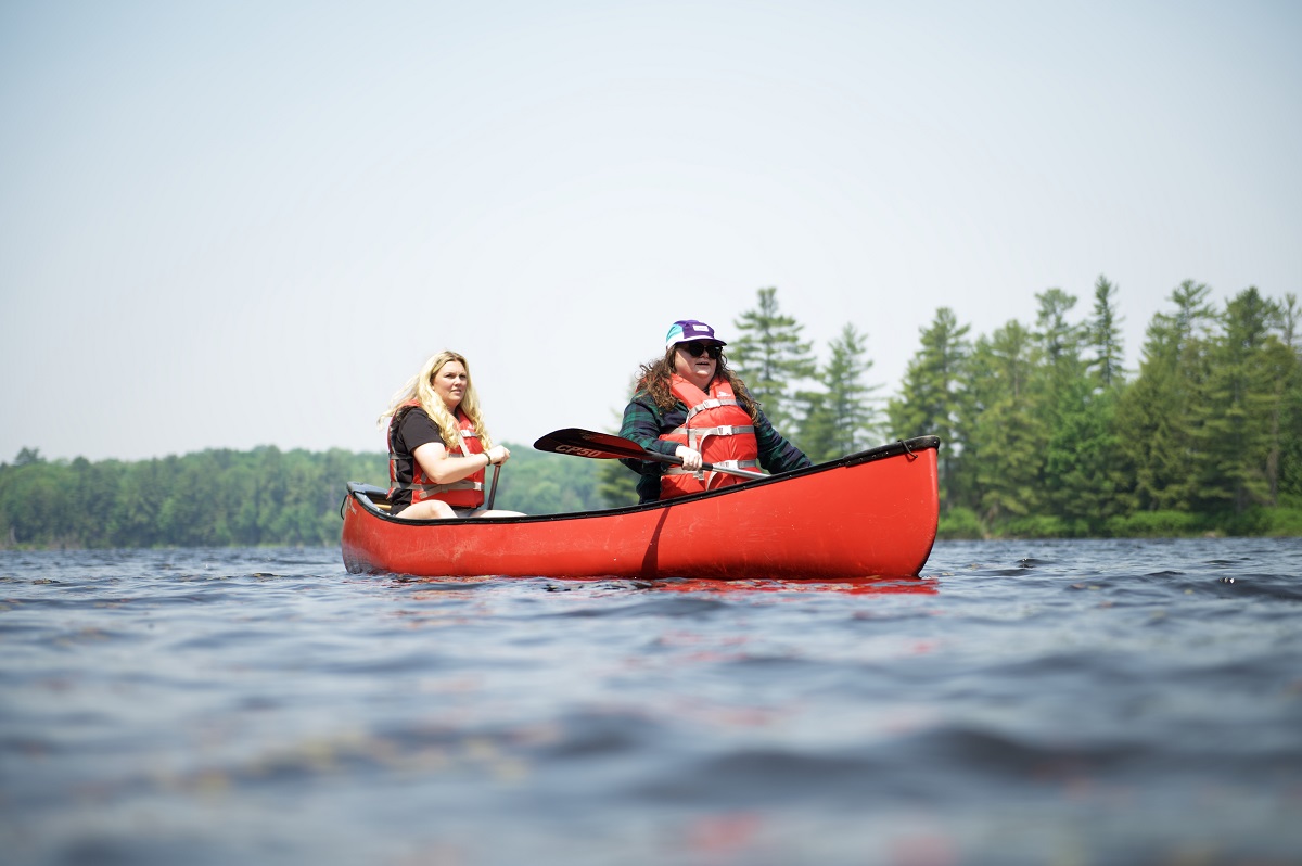 two women in a red canoe on a lake