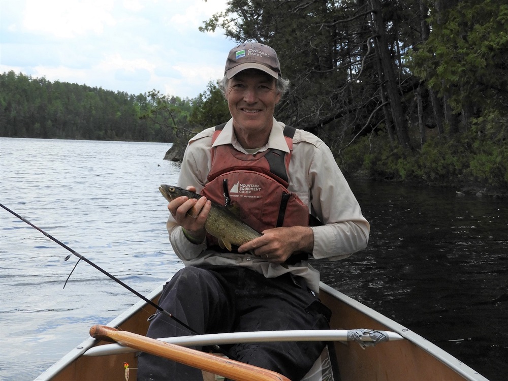 man holding fish in canoe