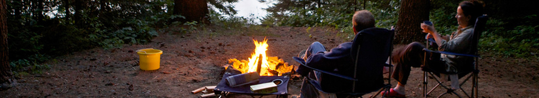 Two people sitting around a campfire