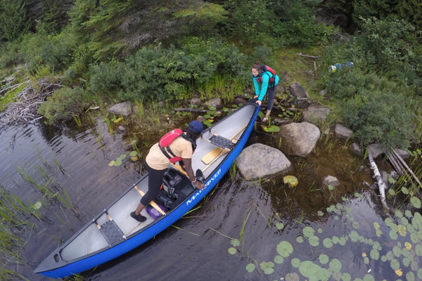 two people getting out of a canoe