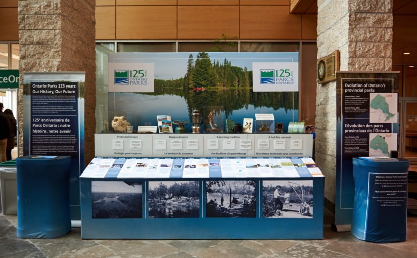 Magnifique présentation mettant en vedette une grande image d’un lac avec une forêt en arrière-plan, le logo de Parcs Ontario en anglais et en français, ainsi qu’un tableau chronologique de l’histoire de Parcs Ontario.