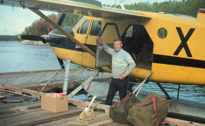 Un type se tenant devant un avion de brousse jaune