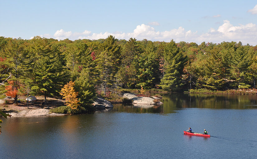 Vue aérienne d’un canot sur un lac en automne