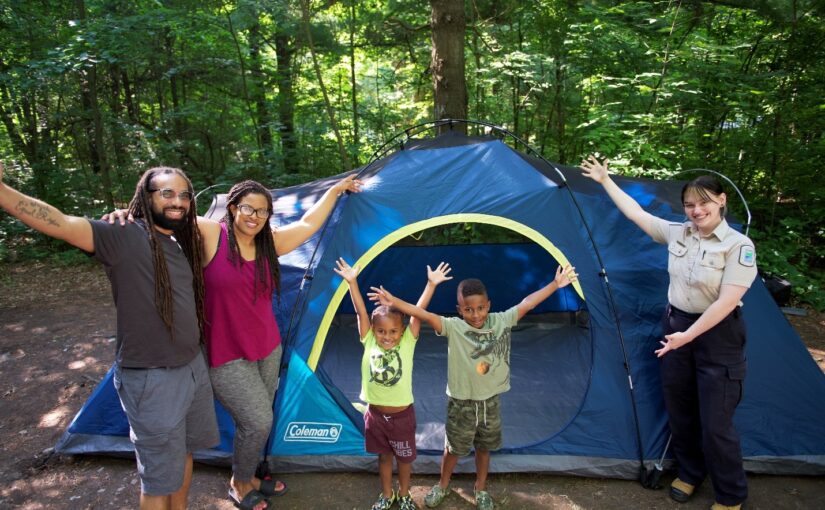 Une famille et une employée à l’extérieur d’une tente
