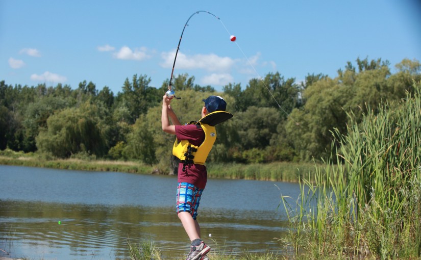 A young boy fishing along the shores of Darlington Provincial Park