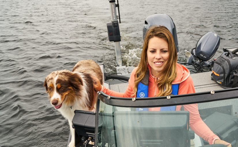 Ashley Rae drives her boat with her dog Blitz