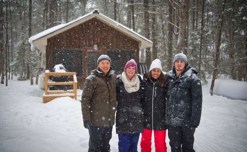 Group in front of cabin in snow