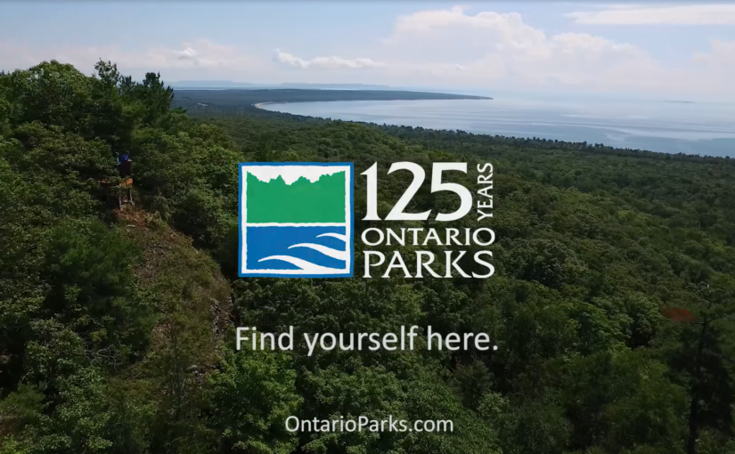 OP125 logo on top of lookout over lake and forest