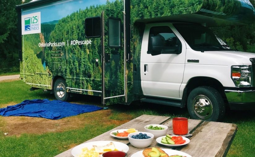 Delicious, healthy breakfast in the foreground of an Ontario Parks wrapped RV