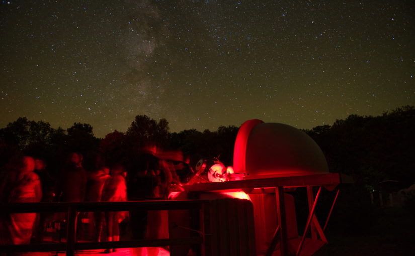 telescope against backdrop of starry night skies