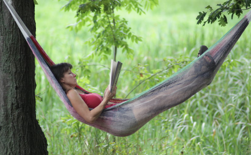 Woman relaxing in a hammock and reading